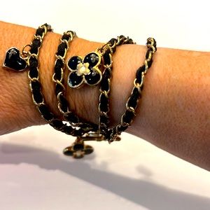 Black double twist bracket w/gold flower and heart charms, great used condition.
